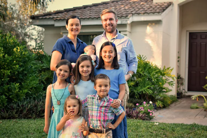 Greg Colker with his wife and children in front of their home in Ave Maria
